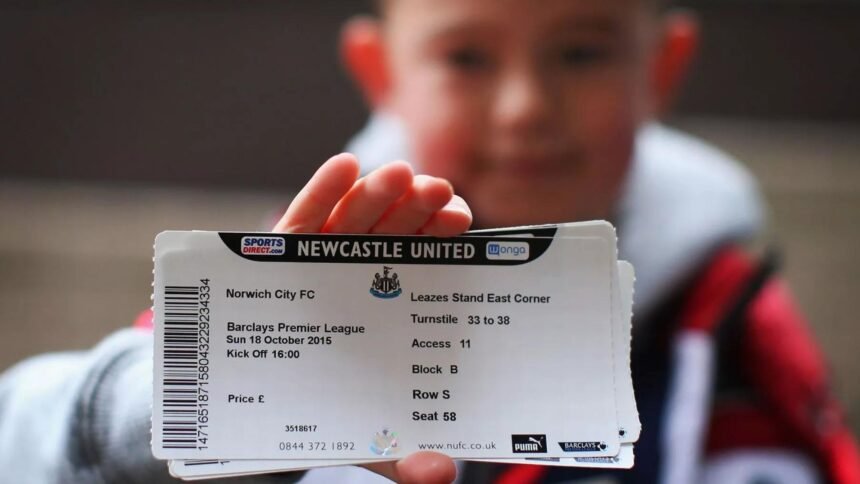 A boy holding football tickets in his hand