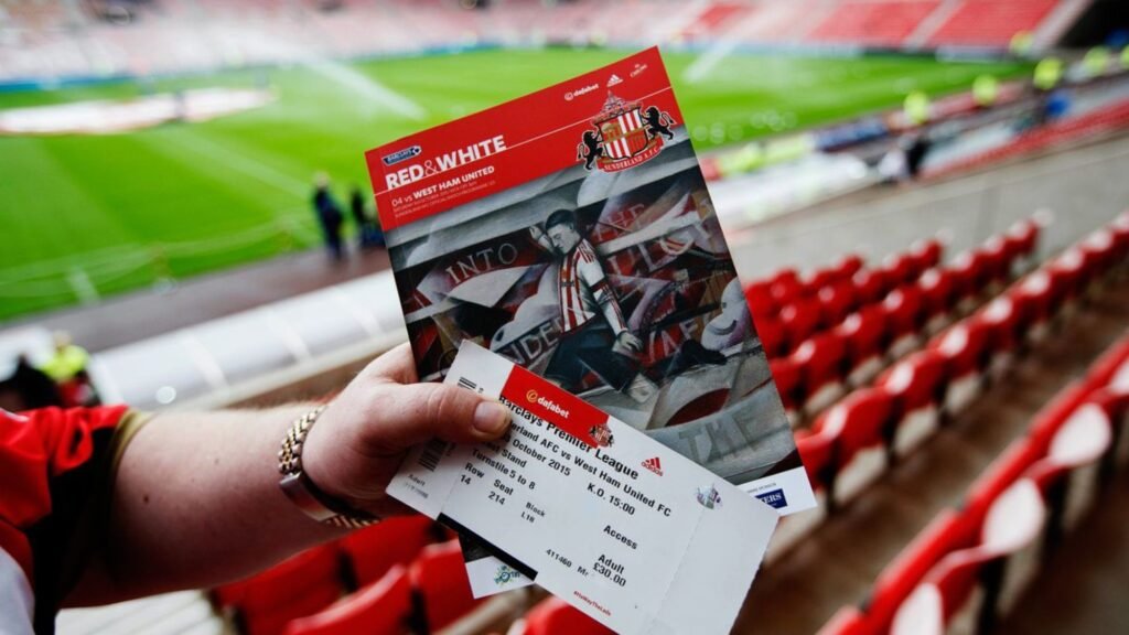 A person holding Premier league football tickets